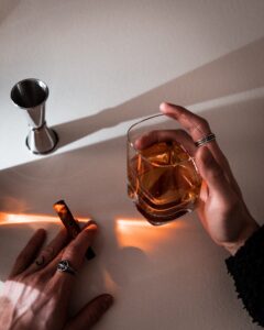 person holding clear glass bottle